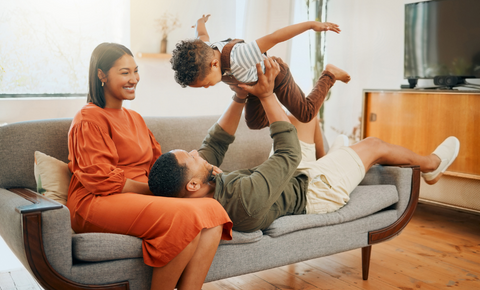 Family on couch playing with child